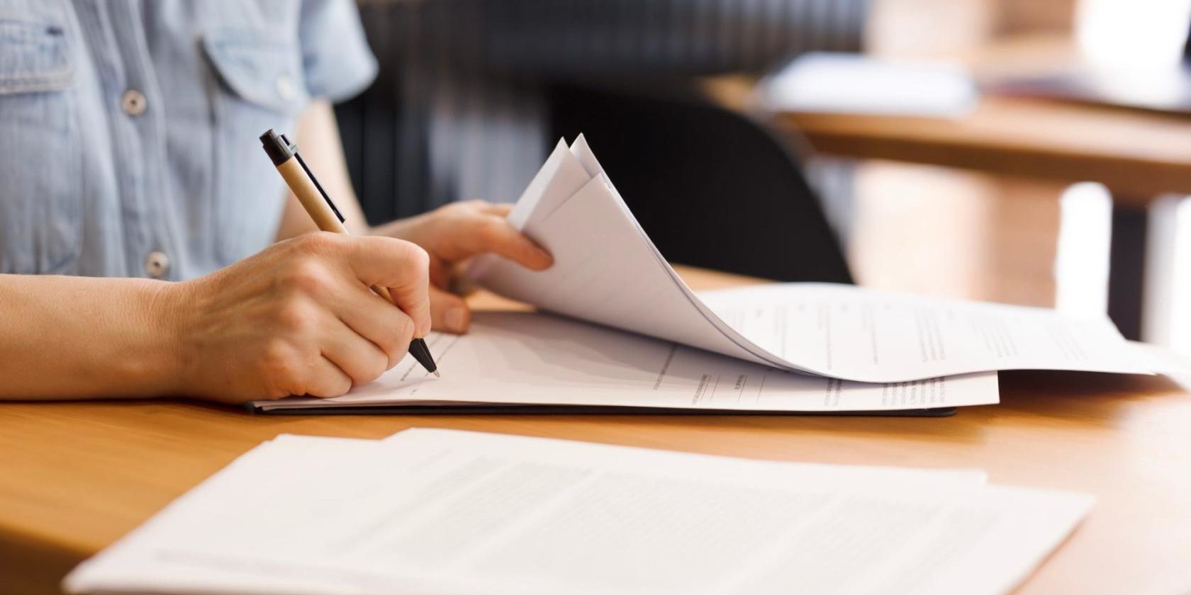 Female,Hands,With,Pen,Signing,Documents,,Business,Papers,On,Wooden