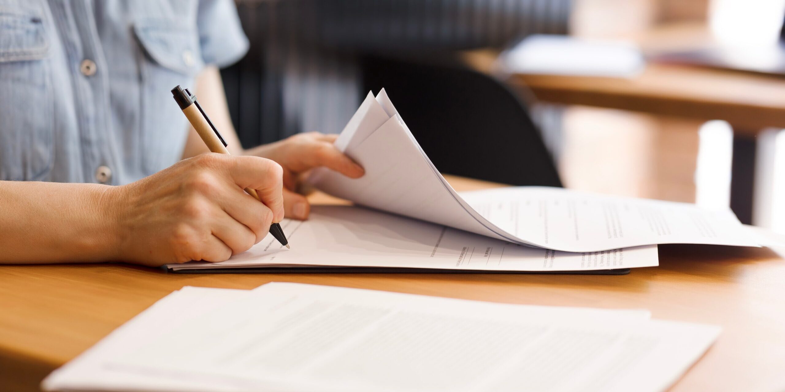 Female,Hands,With,Pen,Signing,Documents,,Business,Papers,On,Wooden