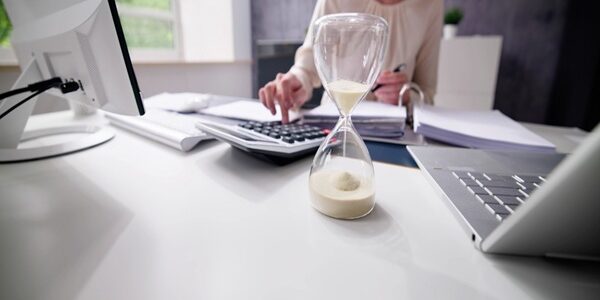 Late,Invoice,And,Billing,Deadline,With,Hourglass,At,Desk