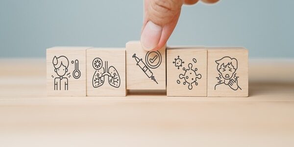 Close,Up,Of,Hand,Placing,Wooden,Block,With,Syringe,And